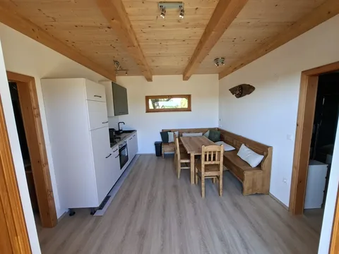Wohnküche mit Küchenzeile, Eckbank und Esstisch aus Holz