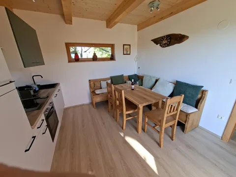Offene Wohnküche mit Küchenzeile, Eckbank und gedecktem Holztisch