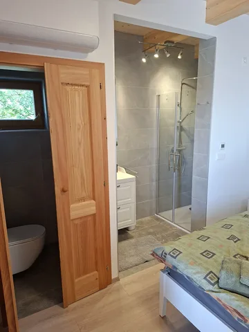 Offene Dusche im Schlafbereich mit Blick vom Bett zur Badnische